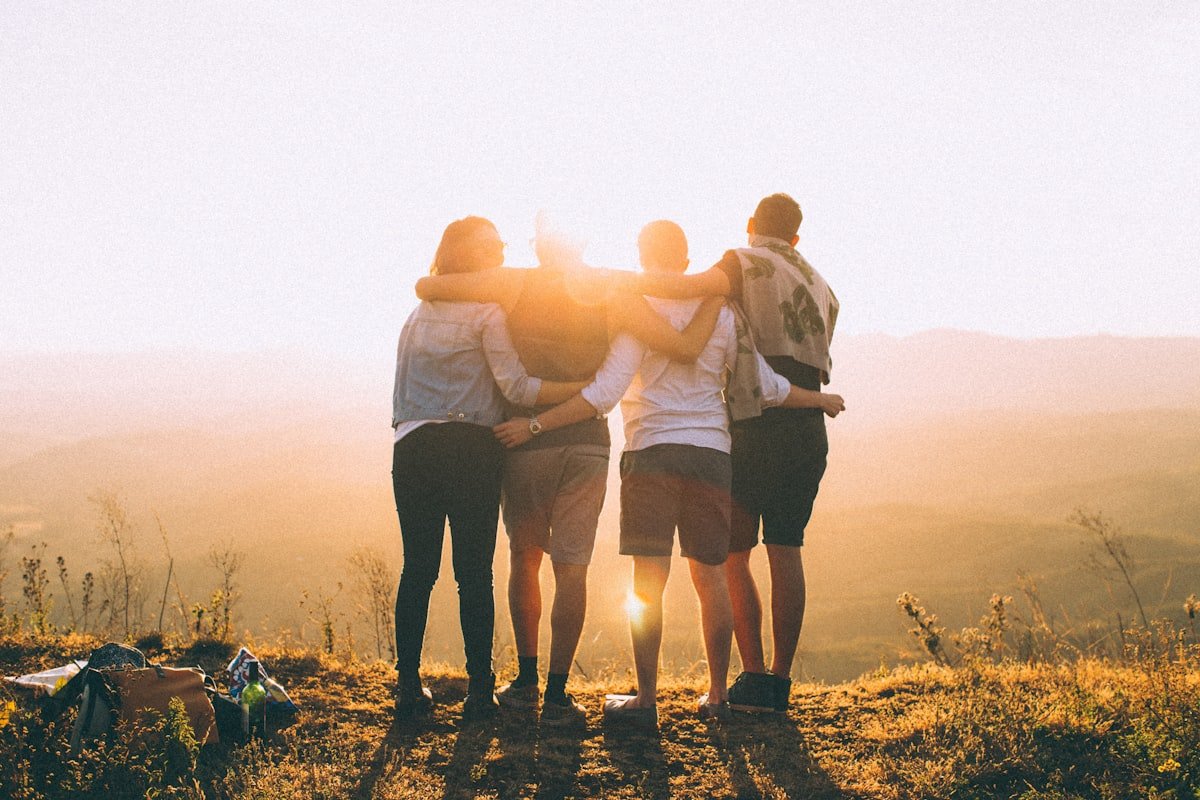 Friends hugging as they watch the sunset
